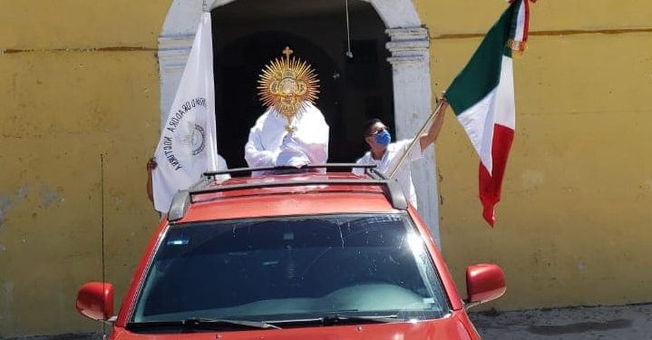 Armado del “Santísimo Sacramento” y de un tapabocas, el presbítero de Dzilam González realiza “peregrinación” abordo de una camioneta con todo y bandera tricolor